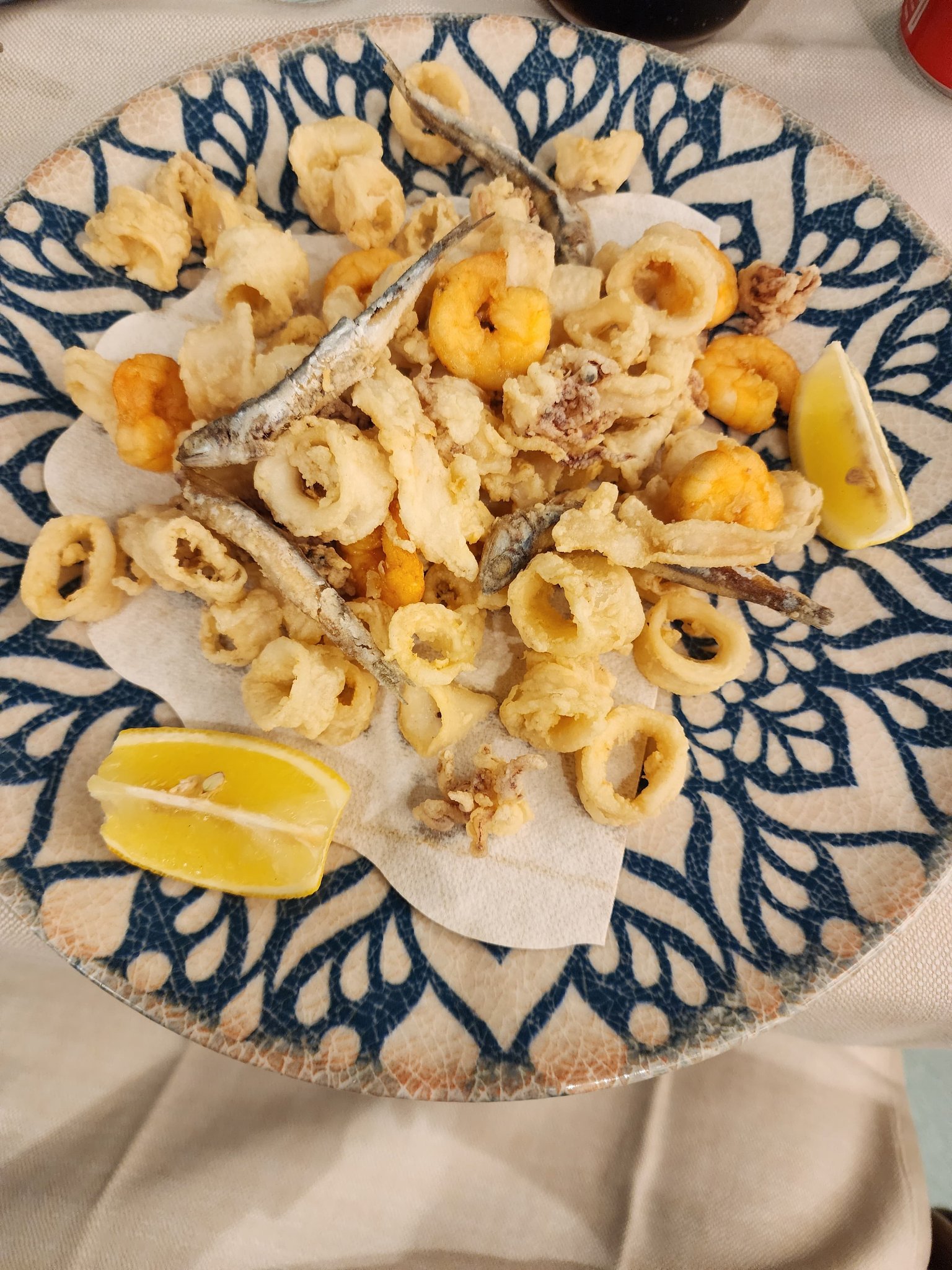Fried calamari, small fish, and seafood served with lemon wedges
