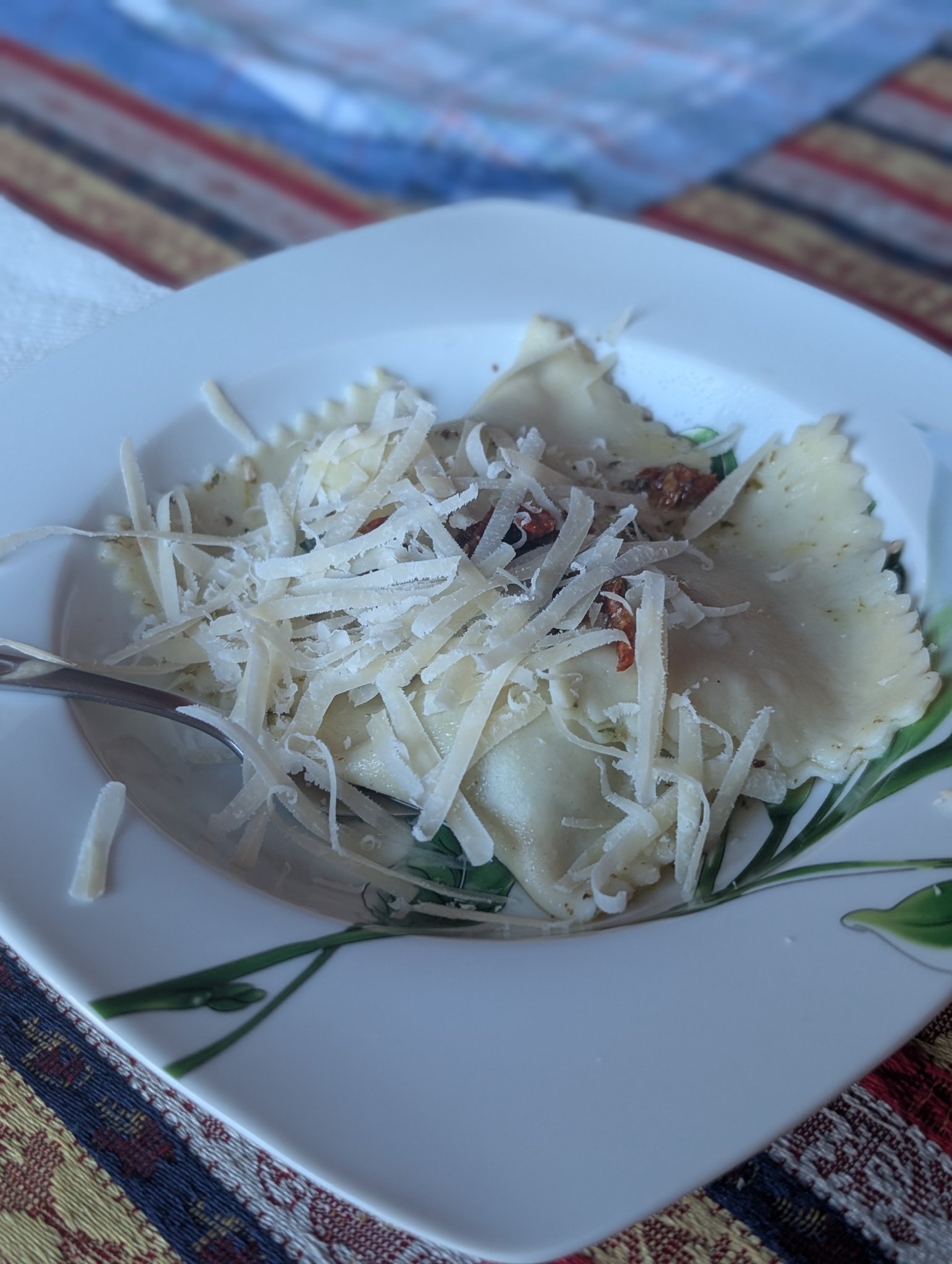 Handmade ravioli topped with sun-dried tomatoes and a generous covering of shredded parmesan