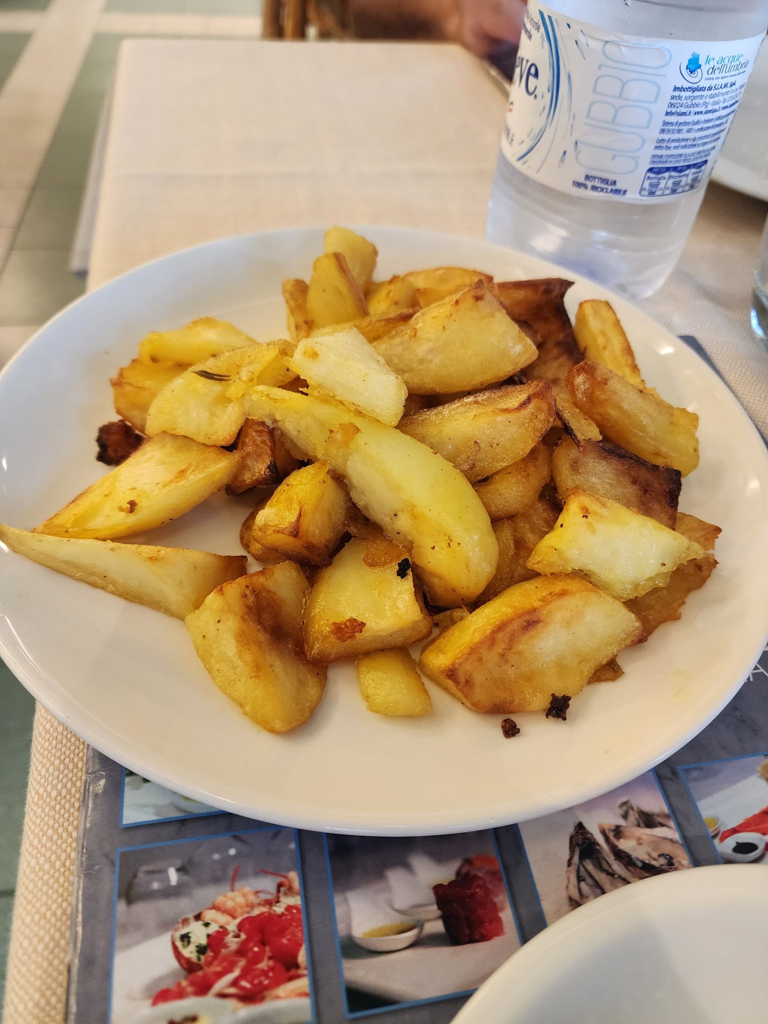 Crispy golden roasted potato wedges served on a white plate
