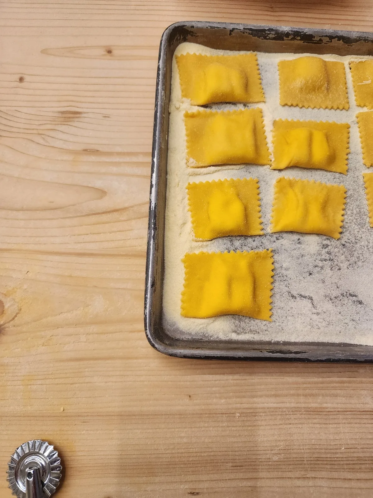 A fresh sheet of pasta dough on a wooden work surface